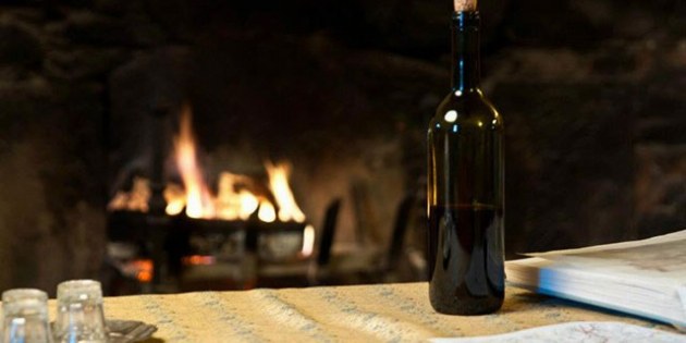 Flasche Wein vor Kaminfeuer