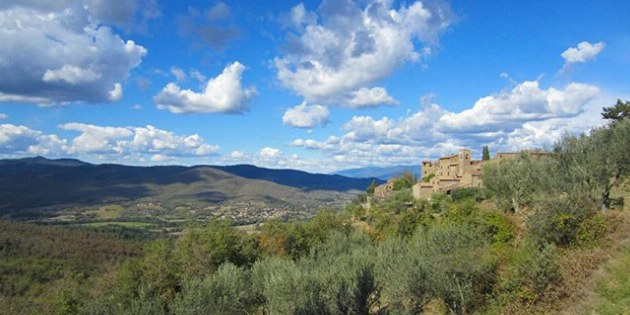 Blick über weite Hügel und typisch toskanisches Dorf