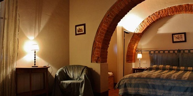 Zimmer mit Bett und blauem Überwurf