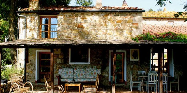 Haus mit Stühlen und Tischen auf der Terrasse